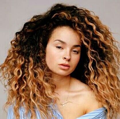 Ella Eyre performing live on stage with microphone, showcasing her powerful raspy voice and confident stage presence