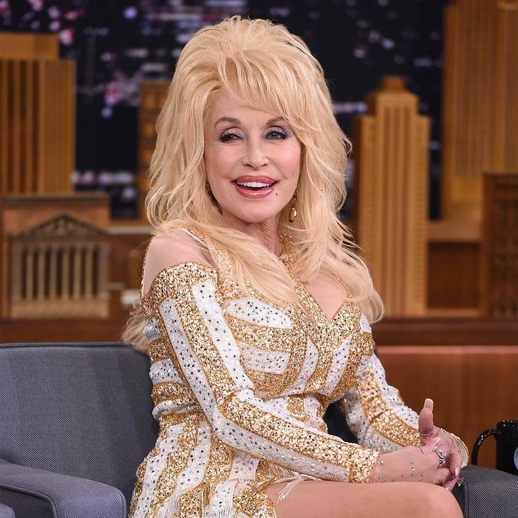 Dolly Parton: 10 Amazing Achievements of the Country Music Legend Dolly Parton performing on stage in signature rhinestones and big hair