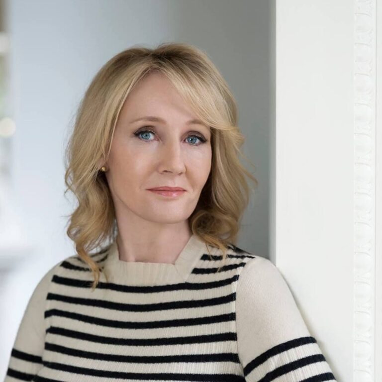 J.K. Rowling smiling at a book signing event, creator of the Harry Potter series