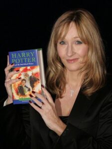J.K. Rowling signing a copy of Harry Potter for fans at a book event