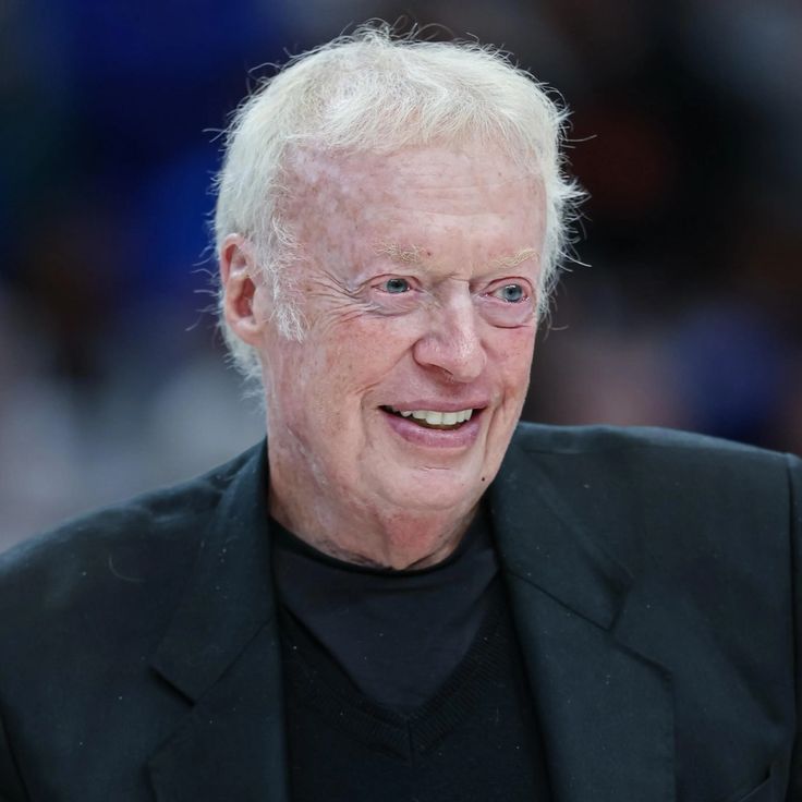 Phil Knight, co-founder of Nike, with iconic Nike sneakers and the Swoosh logo.