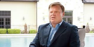 Richard LeFrak standing in front of LeFrak City, Queens, New York, showcasing his real estate empire.